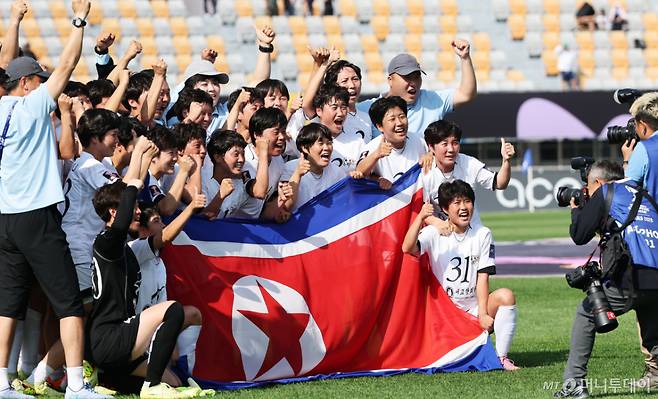 (수원=뉴스1) 박지혜 기자 = 23일 오후 경기 수원시 수원종합운동장에서 열린 2025-2026 아시아축구연맹(AFC) 여자 챔피언스리그(AWCL) 결승 도쿄 베르디의 경기에서 1-0으로 승리하며 사상 첫 정상에 오른 내고향여자축구단 선수들이 인공기를 들고 기념촬영을 하고 있다. 2026.5.23/뉴스1  Copyright (C) 뉴스1. All rights reserved. 무단 전재 및 재배포,  AI학습 이용 금지. /사진=(수원=뉴스1) 박지혜 기자