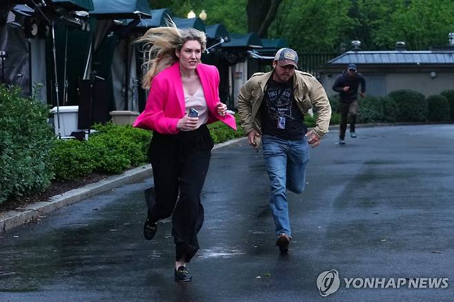 황급히 대피하는 기자들 23일(현지시간) 워싱틴D.C 백악관 인근 총격 발생 당시 북쪽 잔디밭에 있던 기자들이 황급히 대피하고 있다. [EPA=연합뉴스. 재판매 및 DB 금지]