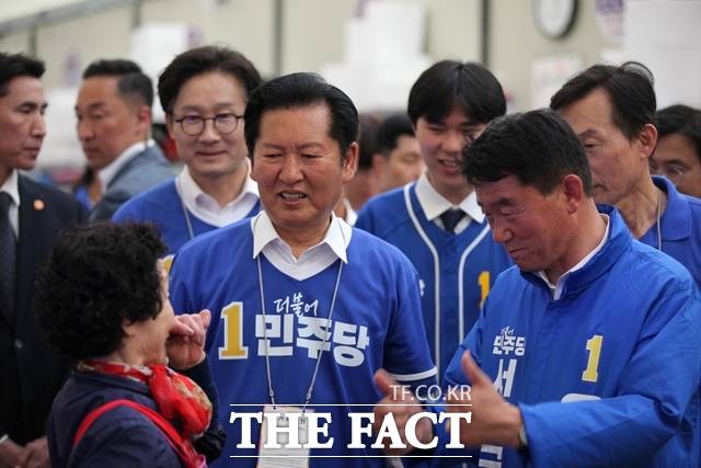 정청래 더불어민주당 대표(가운데)가 충남 서천군 서천특화시장을 찾아 유승광 민주당 서천군수 후보(오른쪽) 지원 유세에 나선 가운데 한 상인과 소통하며 지지를 호소하고 있다. /노경완 기자