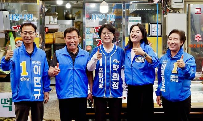 이재정 더불어민주당 국회의원(오른쪽에서 두 번째)이 26일 포항 대해불빛시장에서 박희정 포항시장 후보 등과 함께 시민 경청투어를 진행하면서 ‘기호 1번’을 상징하는 엄지손가락을 들고 환하게 웃고 있다. /박희정 후보 제공
