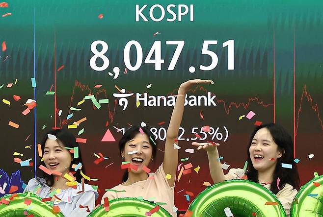 코스피 지수가 종가 기준 최초로 8,000대를 기록한 26일 오후 서울 중구 하나은행 본점 딜링룸에서 직원들이 축하 세레머니를 하고 있다. 뉴스1 제공