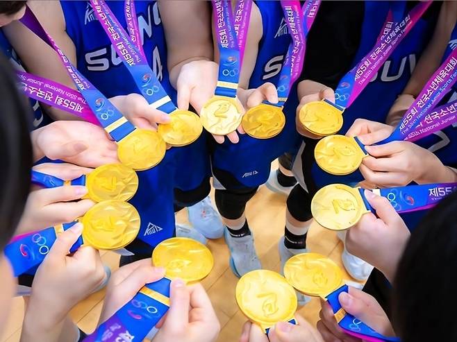 제55회 전국소년체육대회 농구 여자 15세 이하부서 2연패를 달성한 수원제일중 선수들이 금메달을 모으며 사진을 촬영하고 있다 사진=수원제일중학교