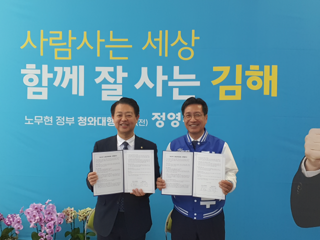 정영두 김해시장 후보(오른쪽)가 26일 선거사무소에서 김영호 국회 교육위원장과 함께 ‘독서국가 김해교육대전환’ 정책 협약을 체결하고 있다./선거 캠프/