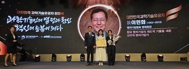 27일 고(故) 이민화 벤처기업협회 명예회장의 유가족이 과학기술유공자 증서와 명패를 받은 후 배경훈 부총리 겸 과학기술정보통신부장관(왼쪽 첫째)과 기념촬영을 하고 있다. [벤처기업협회]
