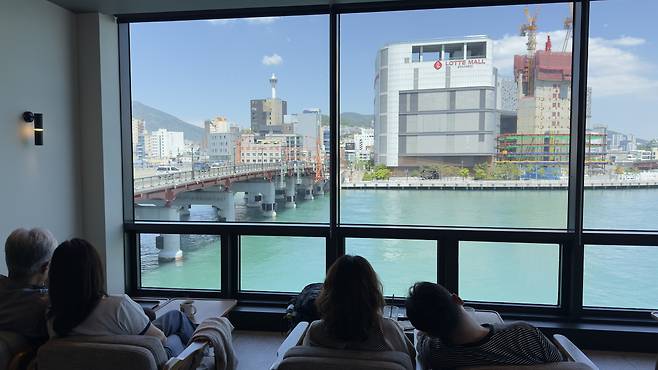 People sit by the window at a nearby cafe to look at Yeongdodaegyo Bridge on May 5. [WOO JI-WON]