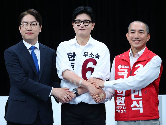 28일 오후 부산 동구 부산MBC에서 열린 북갑 보궐선거 후보자 토론회에서 더불어민주당 하정우(왼쪽부터), 무소속 한동훈, 국민의힘 박민식 후보가 손을 맞잡고 있다.  [사진출처 = 연합뉴스]