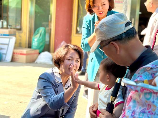 추미애 더불어민주당 경기도지사 후보가 24일 경기도 의왕시 청계사를 찾아 어린아이와 인사를 나누고 있다.(사진=추미애 선거캠프 제공)