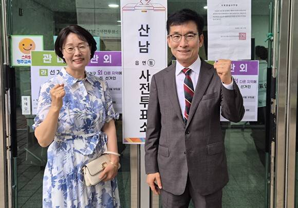 윤건영 충북도교육감 후보가 29일 청주교육지원청에 마련된 산남동 사전투표소 앞에서 부인 하정혜 여사와 기념사진을 찍고 있다. [사진=윤건영 후보]
