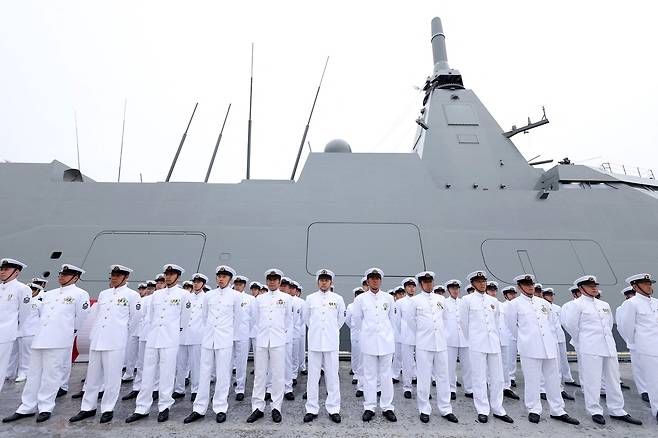 지난 21일 일본 나가사키에 위치한 미쓰비시 중공업 조선소에서 열린 일본 해상자위대 나토리(FFM-9)함 인도식 및 자위대기함 기함 수여식에서 해상자위대 대원들이 모가미급 스텔스 호위함 옆에서 경례하고 있다. AFP 연합뉴스