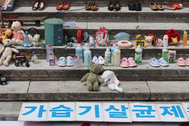 지난해 8월 28일 서울 종로구 세종문화회관 계단에서 열린 가습기살균제 참사 14주년 기자회견에서 태아, 영유아, 어린이 피해 추모를 위한 유품들과 가습기 살균제 등이 전시돼 있다. [사진=연합뉴스]