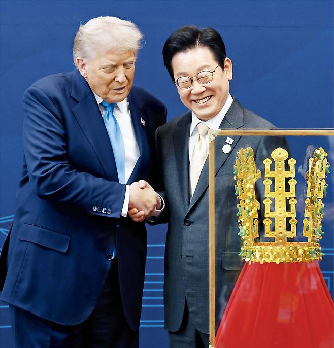 이재명 대통령이 지난해 국립경주박물관에서 도널드 트럼프 미국 대통령에게 신라 천마총 금관 모형을 선물한 뒤 트럼프 대통령과 악수하고 있다. /뉴시스