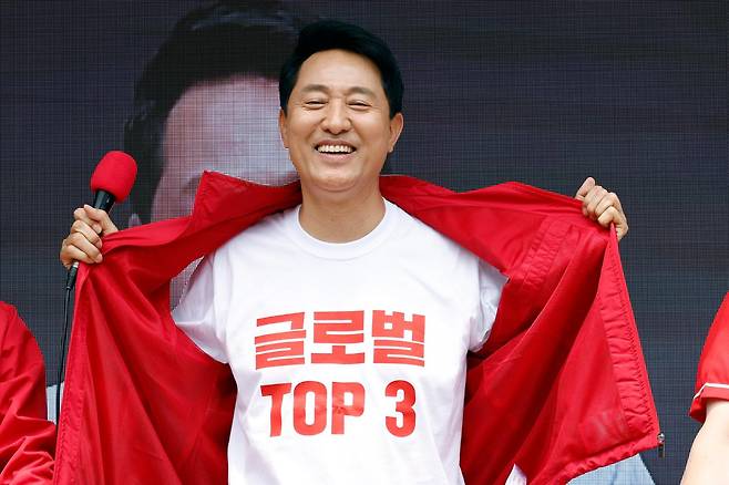 오세훈 국민의힘 서울시장 후보가 1일 서울 노원구 롯데백화점 노원점 앞에서 가진 노원구 릴레이 순회 유세에서 외투 속 티셔츠에 새긴 글로벌 톱3 도시 목표를 공개하고 있다. 뉴스1