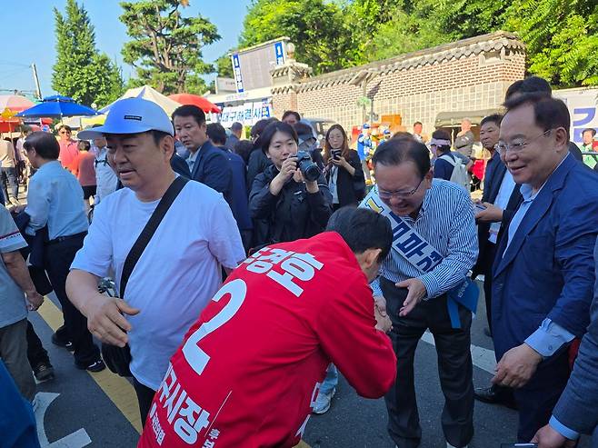 대구시장 선거에 출마한 김부겸 더불어민주당, 추경호 국민의힘 후보가 31일 오전 대구 중구 달성공원 새벽시장에서 만나 인사를 나누고 있다. 대구=하준호 기자
