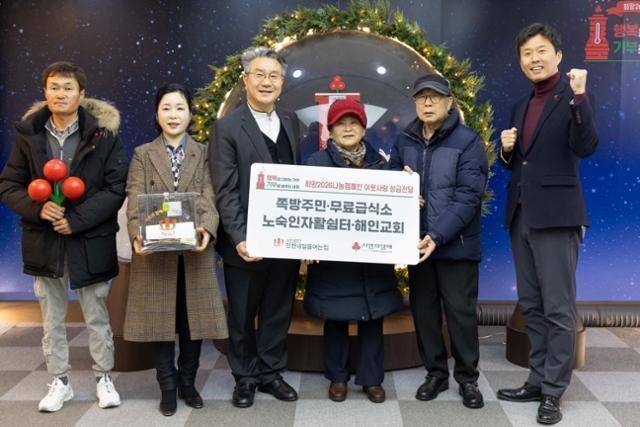 인천의 쪽방촌인 동구 괭이부리마을 주민 대표 권영자(왼쪽 네 번째)씨와 무료급식소 이용자 대표 이동승(다섯 번째)씨, 이준모(세 번째) 사단법인 인천내일을여는집 이사장 등이 1월 27일 서울 중구 사랑의열매회관에서 사랑의열매 사회복지공동모금회에 성금을 전달한 뒤 기념사진을 찍고 있다. 모금회 제공