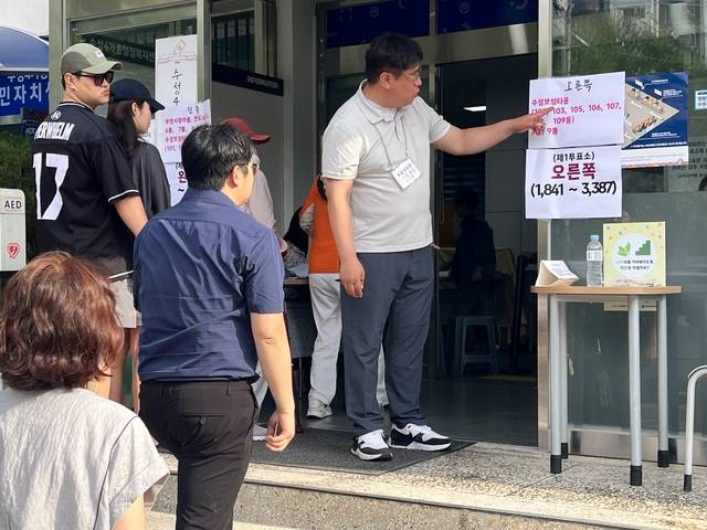 투표소 오인 혼선을 막기위해 선거사무원이 직접 유권자들에게 지정 투표소에 대한 설명을 하고 있다. 김정원 기자