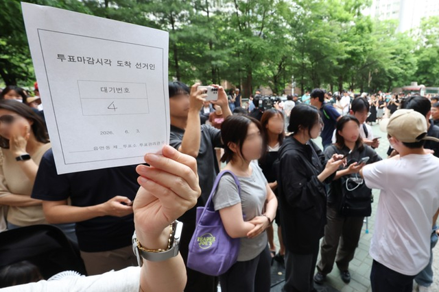 6·3 지방선거 본투표일인 3일 서울 송파구 잠실2동6투표소에서 투표용지 부족으로 유권자들이 대기하는 등 혼란이 빚어지고 있다. 한 시민이 투표 마감시간 이후 순서대로 투표가 가능하도록 정한 대기표를 받아 보여주고 있다. [연합뉴스]