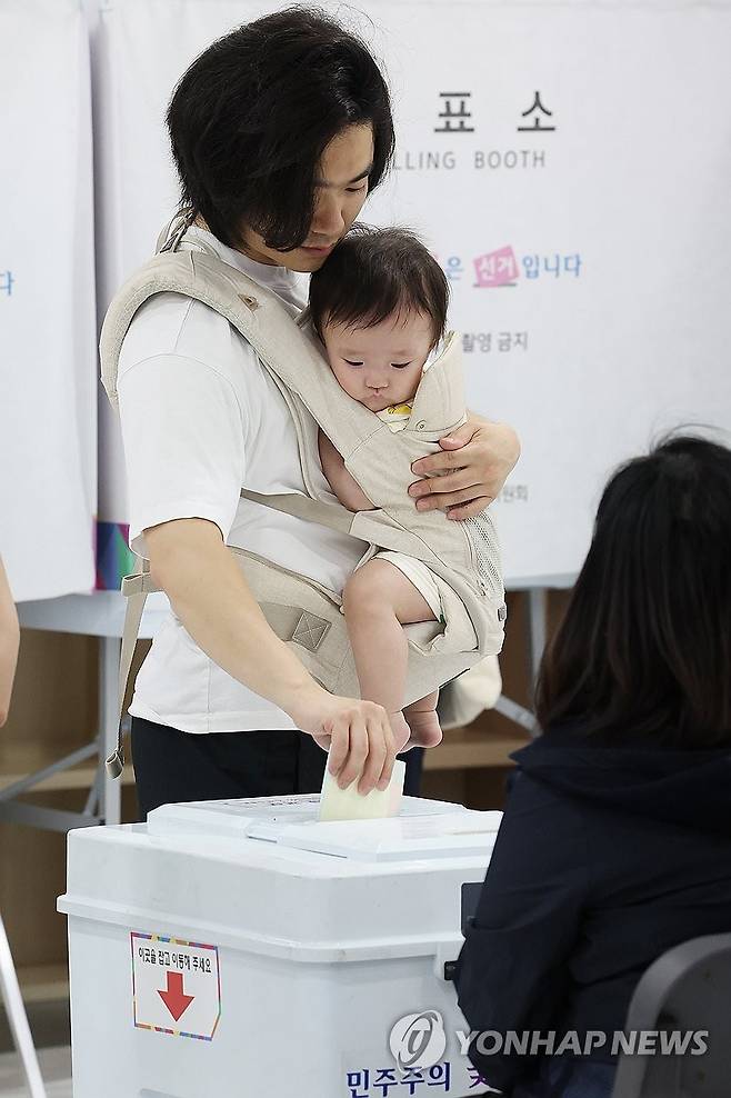 아기와 투표 (서울=연합뉴스) 강민지 기자 = 제9회 전국동시지방선거일인 3일 서울 강서구 현대태권도 체육관에 마련된 화곡제8동제5투표소에서 아이를 안은 유권자가 투표를 하고 있다. 2026.6.3 mjkang@yna.co.kr