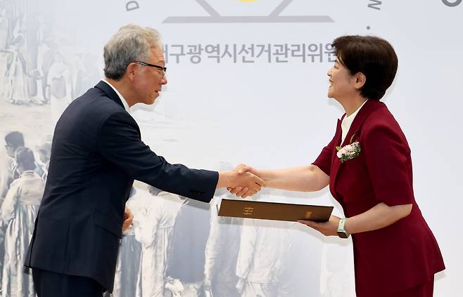 제9회 전국동시지방선거 당선인에 대한 당선증 교부식이 4일 오후 대구시선관위 강당에서 열렸다. 강동명 대구시선관위원장(왼쪽)이 강은희 대구시교육감 당선인에게 당선증을 전달하고 있다. /이용선기자 photokid@kbmaeil.com