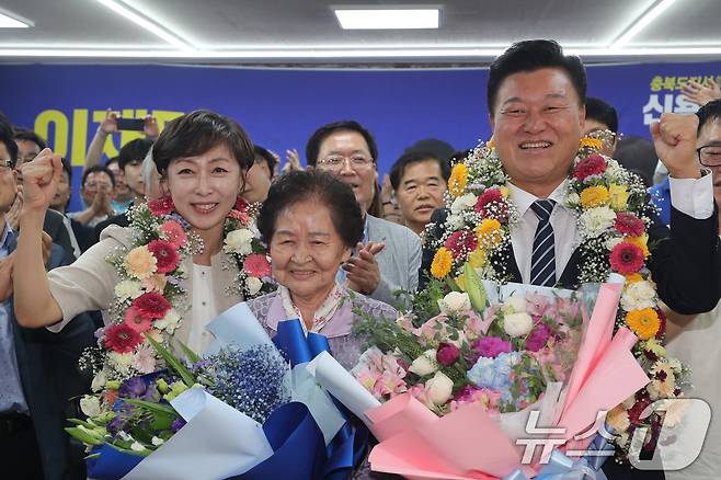 더불어민주당 신용한 충북지사 후보와 어머니, 배우자 이채영 씨가 3일 오후 충북 청주시 흥덕구 선거사무소에서 당선이 유력시되자 꽃목걸이를 걸고 세리머니를 하고 있다. 2026.6.3 ⓒ 뉴스1 김용빈 기자