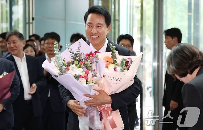 오세훈 서울시장 당선인이 4일 오전 서울시청 로비에서 직원들이 준비해 준 꽃다발을 받고 기뻐하고 있다. (공동취재) 2026.6.4 ⓒ 뉴스1 이호윤 기자