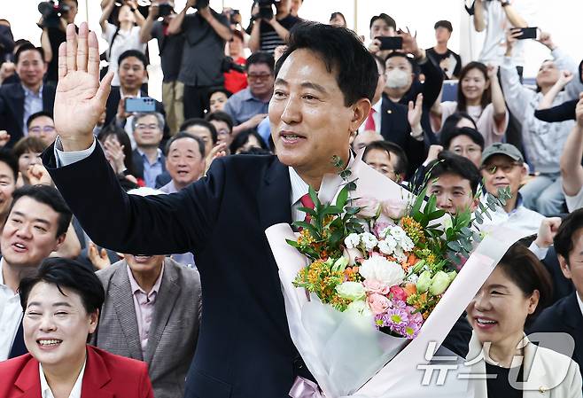 6·3 지방선거에서 당선된 오세훈 국민의힘 서울시장 후보가 4일 서울 종로구 선거사무소에서 꽃다발을 전달 받고 환호 하고 있다. 2026.6.4 ⓒ 뉴스1 김도우 기자