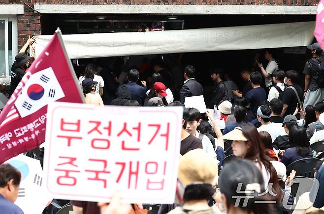 4일 오전 제9회 전국동시지방선거 및 국회의원 재·보궐선거 투표함 이송이 지연되고 있는 서울 송파구 잠실7동 제2투표소에서 시위대와 일부 주민들이 부정선거를 외치며 입구를 봉쇄하고 있다. 2026.6.4 ⓒ 뉴스1 김민지 기자