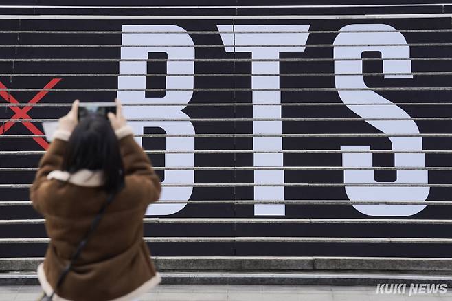 외국인 관광객이 서울 종로구 세종문화회관 계단에 부착된 그룹 방탄소년단(BTS) 컴백 공연 홍보물 앞에서 사진을 찍고 있다. 남동균 기자