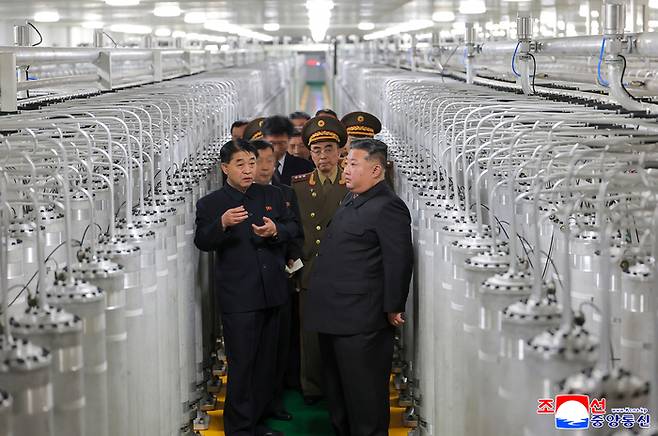 김정은 북한 국무위원장이 지난 3일 최성남 군수공업부 부부장과 함께 새로 가동한 핵물질 생산공장에서 원심분리기 사이로 생산공장을 둘러보고 있다. 김 위원장 뒤로 강경호 핵무기연구소 부소장이 수행하고 있다. [조선중앙통신·연합뉴스]