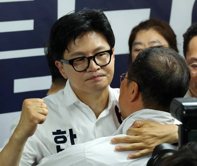 한동훈 무소속 부산 북구 갑 국회의원 보궐선거 후보가 4일 부산 북구 선거사무소에서 당선이 확정된 후 선거사무소 관계자와 포옹하며 주먹을 불끈 쥐고 있다. 연합뉴스