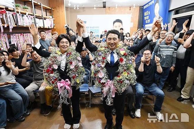 [함평=뉴시스] 이현행 기자 = 제9회 전국동시지방선거 전남 함평군수로 당선된 더불어민주당 이남오(오른쪽) 당선인이 4일 오전 함평군 함평읍 자신의 선거사무소에서 아내 이수인씨와 꽃목걸이를 걸고 만세 하고 있다. 2026.06.04. lhh@newsis.com