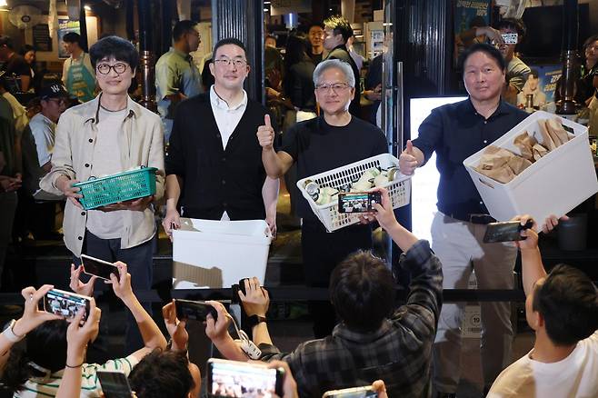 젠슨 황(오른쪽 두 번째) 엔비디아 CEO가 5일 서울 마포구 홍익대 인근 고깃집에서 최태원(첫 번째) SK그룹 회장, 구광모(세 번째) LG그룹 회장, 이해진 네이버 의장과 저녁식사를 한 뒤 식당 밖에 모인 시민들에게 간식을 나눠주기 전 엄지 손가락을 치켜들고 있다. 뉴스1