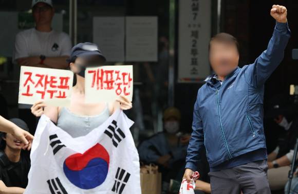 제9회 전국동시지방선거 및 국회의원 재·보궐선거 투표용지 부족으로 투표 시간이 오후 10시까지 연장됐던 서울 송파구 잠실7동 제2투표소 앞에서 4일 투표함 반출에 반대하는 시민들이 구호를 외치고 있다. [사진=연합뉴스]