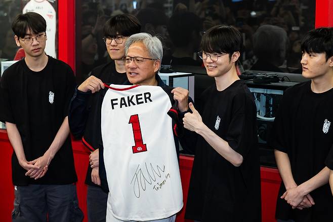 엔비디아 젠슨 황 최고경영자(CEO)가 5일 서울 마포구 T1베이스 캠프에서 ‘페이커’ 이상혁 선수를 비롯한 e스포츠 구단 T1의 리그 오브 레전드(LoL) 선수단을 만나 페이커의 사인이 담긴 기념품을 선물 받고 있다. 연합뉴스