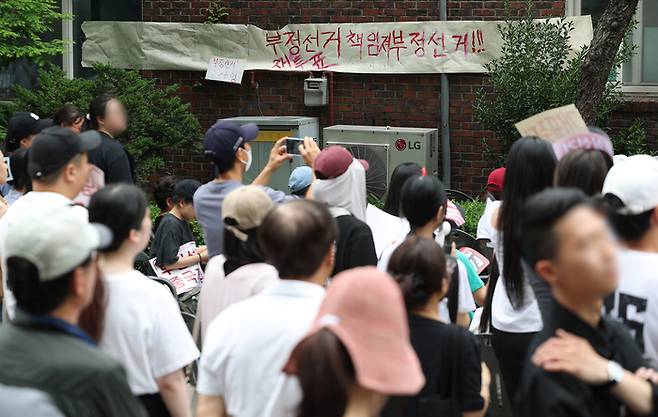 지난 3일 9회 전국동시지방선거 및 국회의원 재·보궐선거 투표용지 부족으로 투표 시간이 오후 10시까지 연장됐던 서울 송파구 잠실7동 제2투표소 앞에서 4일 투표함 반출에 반대하는 시민들이 모여 있다. [연합뉴스]