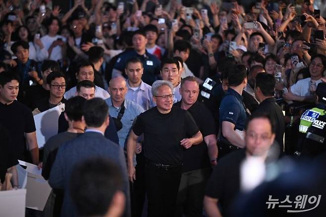 젠슨 황 엔비디아 창립자 겸 최고경영자가 5일 오후 서울 마포구 형님저요 고깃집에서 최태원 SK그룹 회장, 구광모 LG그룹 회장, 이해진 네이버 의장과 함께 '삼겹살 회동'을 하던 중 잠시 시민들에게 준비한 선물을 전달 완료 후 다시 식당으로 향하고 있다. 사진=강민석 기자