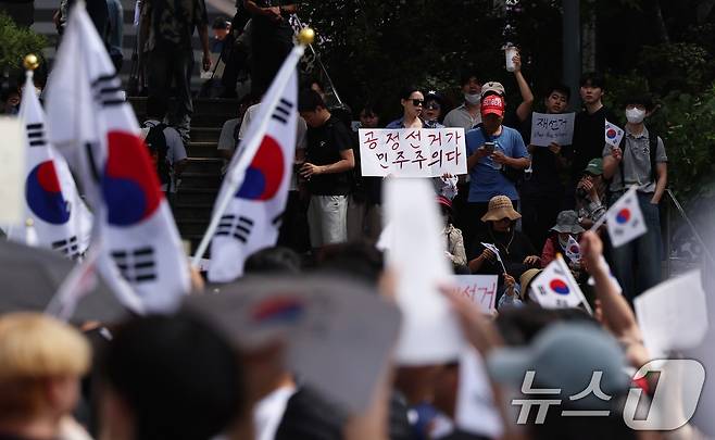 6·3 지방선거 투표용지 부족 사태에 반발한 시민들이 6일 오전 서울 송파구 올림픽공원 핸드볼경기장 개표소 앞에 모여 재선거를 요구하는 구호를 외치고 있다. 2026.6.6 ⓒ 뉴스1 구윤성 기자