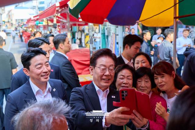 지난달 18일 이재명 대통령이 한일 정상회담을 하루 앞두고 고향 안동 구시장을 찾아 시민들과 사진을 찍고 있다. [청와대]