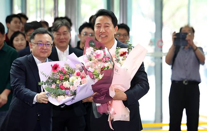 오세훈 국민의힘 후보가 서울시장으로 당선되며, 공약으로 내세운 서울고속버스터미널 재개발 관련주가 강세를 보였다. 사진은 오세훈 서울시장이 지난 6월 4일 서울시청으로 들어서며 직원들에게 받은 꽃다발을 들고 있는 모습. (연합뉴스)