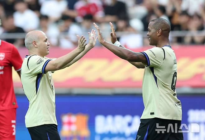 [서울=뉴시스] 황준선 기자 = 6일 오후 서울 마포구 서울월드컵경기장에서 열린 '2026 챔피언스 임팩트 인 서울' 바르사 레전드와 더 레즈 레전드의 경기, 팀의 첫 번째 골을 넣은 바르사 파트릭 클라위버르트가 이니에스타와 기쁨을 나누고 있다 .2026.06.06. hwang@newsis.com