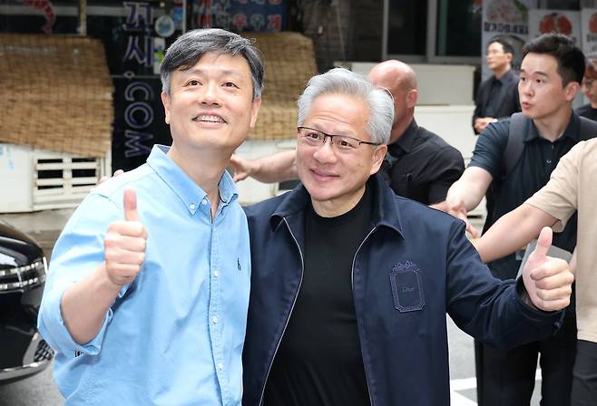 젠슨 황 엔비디아 최고경영자(CEO)와 장병규 크래프톤 의장(왼쪽)이 7일 서울 강남구에 있는 한 PC방 앞에서 만나 기념 촬영을 하고 있다.(연합뉴스)