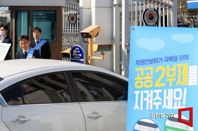 중동전쟁 장기화에 따라 공공기관 차량 5부제가 홀짝제인 '2부제'로 강화된 지난 4월8일 서울 종로구 정부서울청사 앞에서 직원들이 운전자들에게 2부제 시행 안내를 하고 있다.
