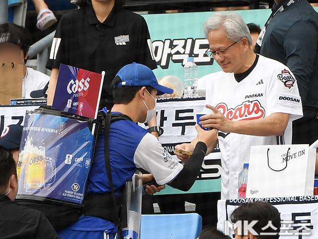 7일 서울 잠실야구장에서 ‘2026 프로야구’ 키움 히어로즈와 두산 베어스의 경기가 열렸다. 이날 시구는 엔비디아 최고경영자(CEO) 젠슨황이 나섰다. 젠슨황은 엔비디아 창립 연도인 1993년을 뜻하는 ‘93 ’번 유니폼을 입고 시구를 진행했다. 박정원 두산그룹 회장은 두산 창립 연도(1896년)를 의미하는 ‘96’ 번 유니폼을 입고 시타자로 나서 투타 호흡을 맞췄다. 젠슨황이 맥주를 사며 5만원 지폐를 건네고 있다. 사진(잠실 서울)=천정환 기자