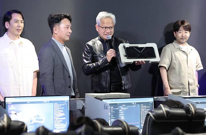 젠슨 황 엔비디아 최고경영자(CEO)와 김택진 엔씨 대표가 7일 서울 강남구의 한 PC방에서 열린 AION2 서프라이즈 라이브에서 최신 그래픽카드를 소개하고 있다. [공동취재·연합]