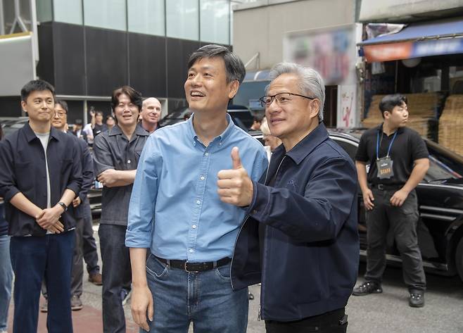 장병규(왼쪽) 크래프톤 의장과 젠슨 황 엔비디아 최고경영자(CEO)가 7일 서울 강남구의 한 PC방 앞에서 만나 인사를 나누는 모습 [크래프톤 제공]