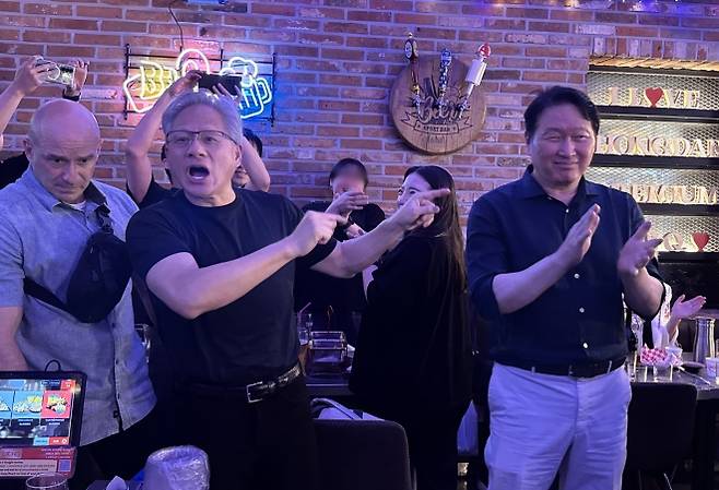 젠슨 황(가운데) 엔비디아 CEO가 지난 5일 서울 마포구 비비큐(BBQ) 홍대입구점에서 최태원(오른쪽) SK그룹 회장, 구광모 LG그룹 회장, 이해진 네이버 의장 등과 대화하고 있다. 연합뉴스