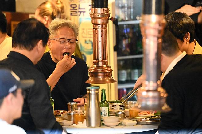 젠슨 황 엔비디아 CEO가 최태원(맨 왼쪽) SK그룹 회장, 구광모(오른쪽 두 번째) LG그룹 회장, 이해진 네이버 의장과 5일 서울 마포구 삼겹살 음식점 '형님 저요'에서 저녁을 먹으며 쌈을 입안에 넣고 있다. 박시몬 기자