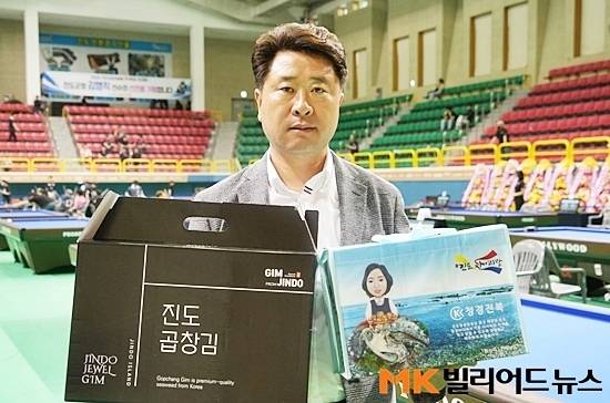 이번 진도아리랑배에선 출전선수를 위해 진도표고버섯, 곱창김, 진도쌀 등 지역 특산품을 준비했다. 진도당구연맹 김연일 회장이 진도군 특산품을 들고 포즈를 취하고 있다.