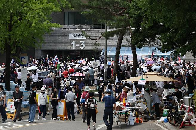 6·3 지방선거 투표용지 부족 사태를 규탄하며 재선거를 요구하는 ‘잠실 개표소 봉쇄 시위’가 계속되고 있는 8일 서울 송파구 올림픽공원 핸드볼경기장 출입구 앞에서 참가자들이 구호를 외치고 있다.[연합뉴스]