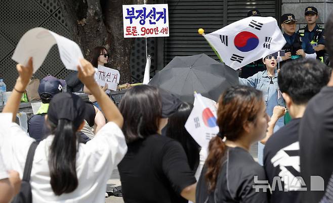 [서울=뉴시스] 김혜진 기자 = 제9회 전국동시지방선거 투표용지 부족 사태에 항의하며 개표소 봉쇄 시위를 이어가는 시민들이 8일 서울 송파구 올림픽공원 핸드볼경기장에 설치된 개표소 앞에서 재선거를 요구하고 있다. 2026.06.08. jini@newsis.com