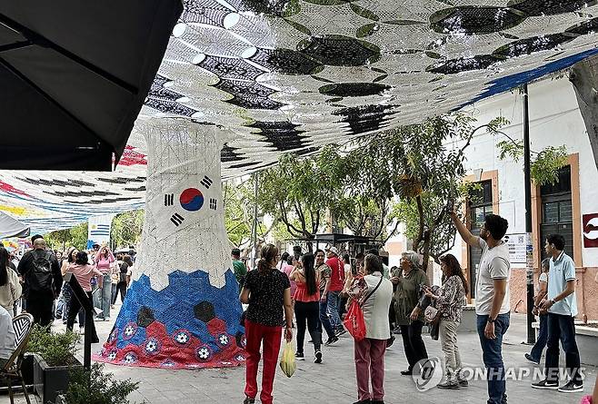 과달라하라 거리의 태극기 조형물 (사포판[멕시코 할리스코주]=연합뉴스) 오명언 기자 = 2026북중미 월드컵이 열리는 멕시코 과달라하라 인근 사포판 역사 지구에 있는 보행자 전용 거리에 이지역에서 경기를 치르는 국가를 상징하는 조형물이 설치되어 있다. 7일(현지시간) 축구유니폼을 입은 시민 등이 한국상징 조형물 아래서 기념사진을 찍고 있다. 2026.6.8 coup@yna.co.kr